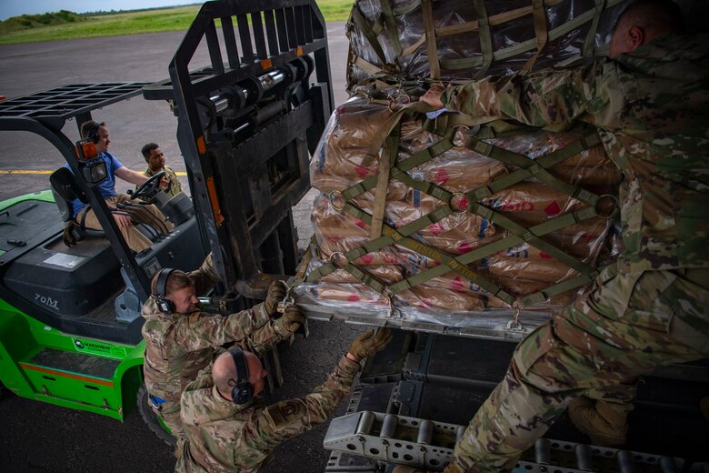 U.S. military personnel load Plumpy Sup from the World Food Programme on a C-17 Globemaster III assigned to the 16th Airlift Squadron, Joint Base Charleston, Charleston, South Carolina, supporting Combined Joint Task Force-Horn of Africa, in Maputo, Mozambique, April 2, 2019. The task force is helping meet requirements identified by the United States Agency for International Development (USAID) assessment teams and humanitarian organizations working in the region by providing logistics support and manpower to USAID at the request of the Government of the Republic of Mozambique. (U.S. Air Force Photo by Tech. Sgt. Chris Hibben)