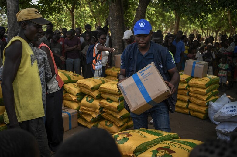 A World Food Programme worker distributes aid to local Mozambicans in Bebedo, Mozambique, April 8, 2019, during humanitarian relief efforts in the Republic of Mozambique and surrounding areas following Cyclone Idai. Teams from Combined Joint Task Force-Horn of Africa, which is leading U.S. Department of Defense support to relief efforts in Mozambique, began immediate preparation to respond following a call for assistance from the U.S. Agency for International Development’s Disaster Assistance Response Team. (U.S. Air Force photo by Staff Sgt. Corban Lundborg)