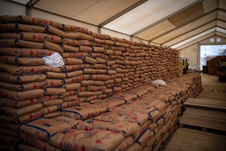 Bags of Corn Soy Blend (CSB) sit in stacks before being loaded on a truck after being flown from Maputo, Mozambique on a C-130J Hercules assigned to the 75th Expeditionary Airlift Squadron, Combined Joint Task Force-Horn of Africa, in Beira, Mozambique, April 6, 2019. The task force is helping meet requirements identified by USAID assessment teams and humanitarian organizations working in the region by providing logistics support and manpower to USAID at the request of the Government of the Republic of Mozambique. (U.S. Air Force Photo by Tech. Sgt. Chris Hibben)