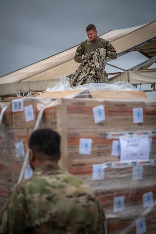 U.S. Air Force Master Sergeant Pat Wagnon, assigned to Combined Joint Task Force-Horn of Africa, takes cargo netting off boxes of food aid in Maputo, Mozambique, April 2, 2019. The task force is helping meet requirements identified by the United States Agency for International Development (USAID) assessment teams and humanitarian organizations working in the region by providing logistics support and manpower to USAID at the request of the Government of the Republic of Mozambique. (U.S. Air Force Photo by Tech. Sgt. Chris Hibben)