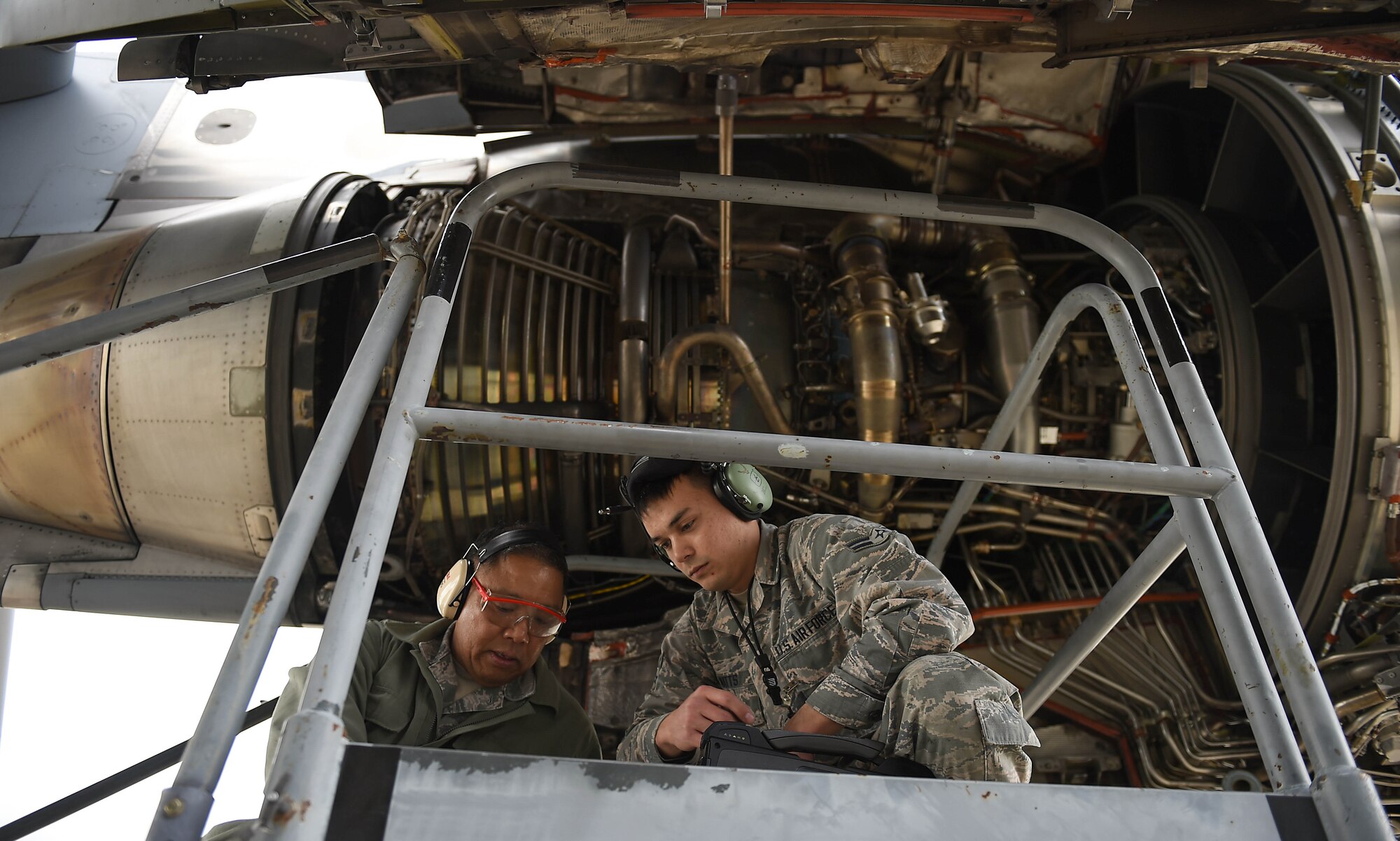 Master Sgt. Ruel Lechadores, 446th Aircraft Maintenance Squadron crew chief, and Airman 1st Class Ryan Watts, 62nd Aircraft Maintenance Squadron crew chief, communicate and work to repair an engine on a C-17 Globemaster III, April 3, 2019, on March Air Reserve Base in California.