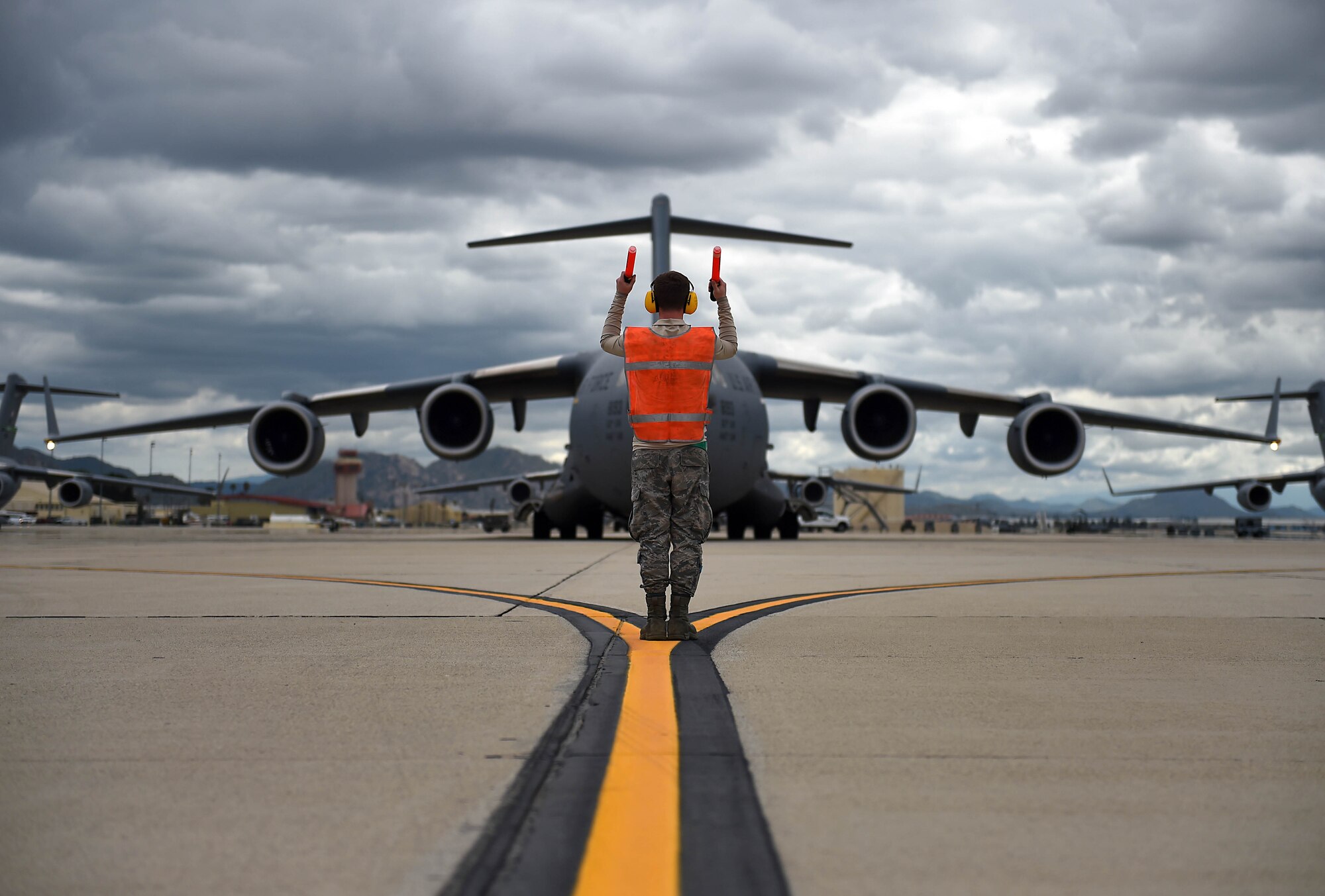 Senior Airman Nathan Cremeans, 62nd Aircraft Maintenance Squadron crew chief, marshals a C-17 Globemaster III as it prepares to take off from March Air Reserve Base in California, April 3, 2019.