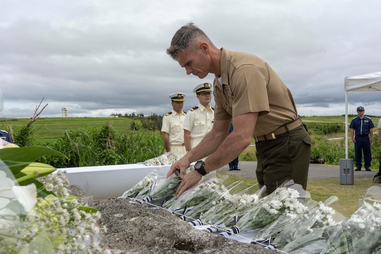 米海兵隊太平洋基地の政務外交部部長のダリン・クラーク米海兵隊大佐が、伊江島灯台殉職者慰霊式で花を手向ける。
