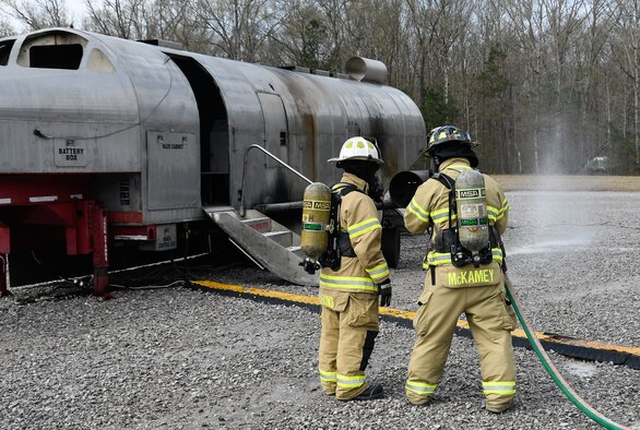 Arnold Air Force Base Firefighter Adam McKamey instructs Jill Pickett, High Mach editor at the base, on how to operate a hand line nozzle during aircraft rescue and firefighting training for the Arnold AFB Fire and Emergency Services personnel at the base. Pickett geared up at the invitation of Assistant Fire Chief Jim Evans, to get a firsthand perspective of the training. (U.S. Air Force photo by Jim Evans)