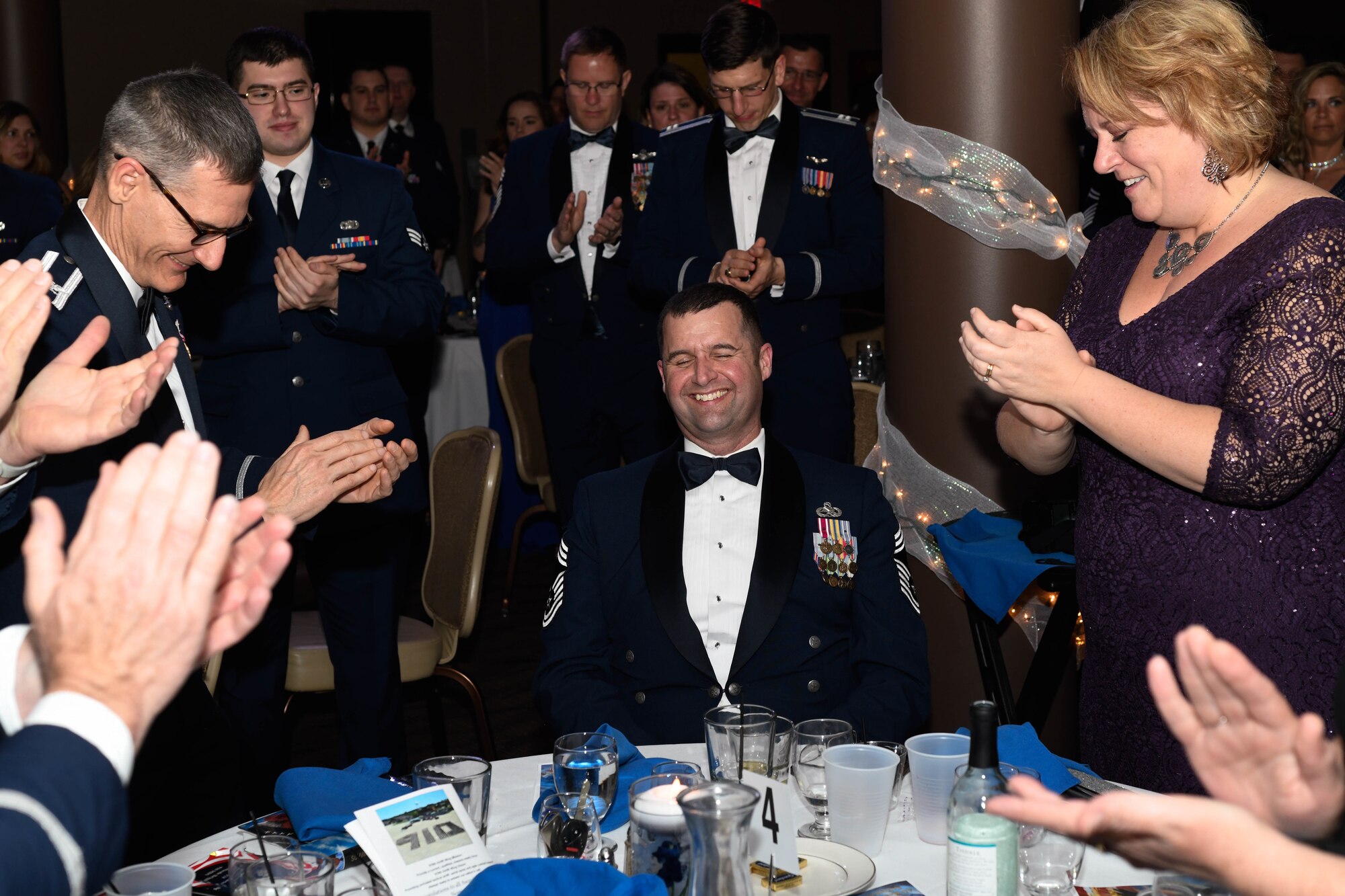 Chief Master Sgt. Robert Potts, former command chief of the 910th Airlift Wing, receives a round of applause after being recognized by Col. Joe Janik, the commander of the 910th AW, during the annual awards banquet in the Community Activity Center here, April 6, 2019.