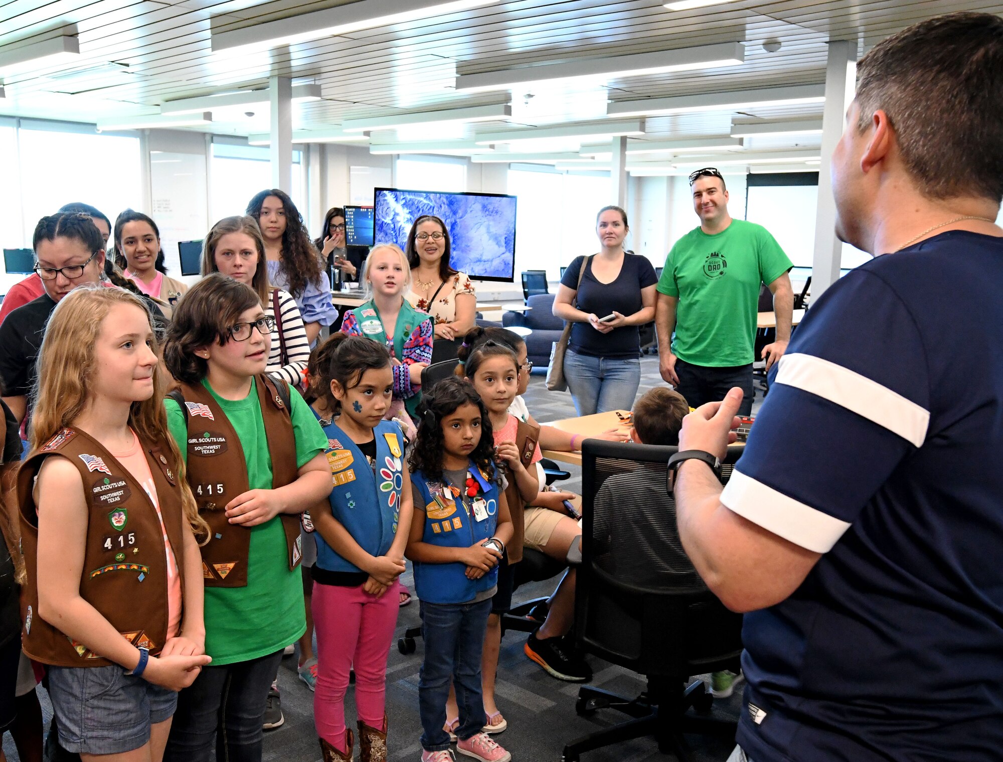 Christopher De La Rosa, 90th Cyberspace Operations Squadron cyber modeling and simulation environments lead, welcomes Girl Scouts to a “Bricks in the Loop” tour in San Antonio, Texas, April 19, 2019. “Bricks in the Loop” mimics an Air Force installation with items such as a fire station, police station, airport, jets and tanker trucks, all used to simulate real-world cyber systems in training cyber operators. (U.S. Air Force photo by Tech. Sgt. R.J. Biermann)