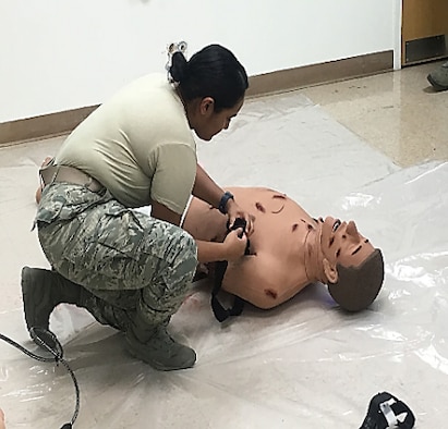 Staff Sgt. Taylor Lopez Boodooram, Active Duty Clinic Office manager, demonstrates tourniquet placement on a manikin’s arm during a National Association of Emergency Medical Technicians Tactical Combat Casualty Care course in the 366th Medical Group Simulation Lab Room at Mountain Air Force Base, Idaho, February 2019. TCCC is a standardized course offered across the military to equip warfighters with basic skills to save lives in combat operations. (Courtesy photo)