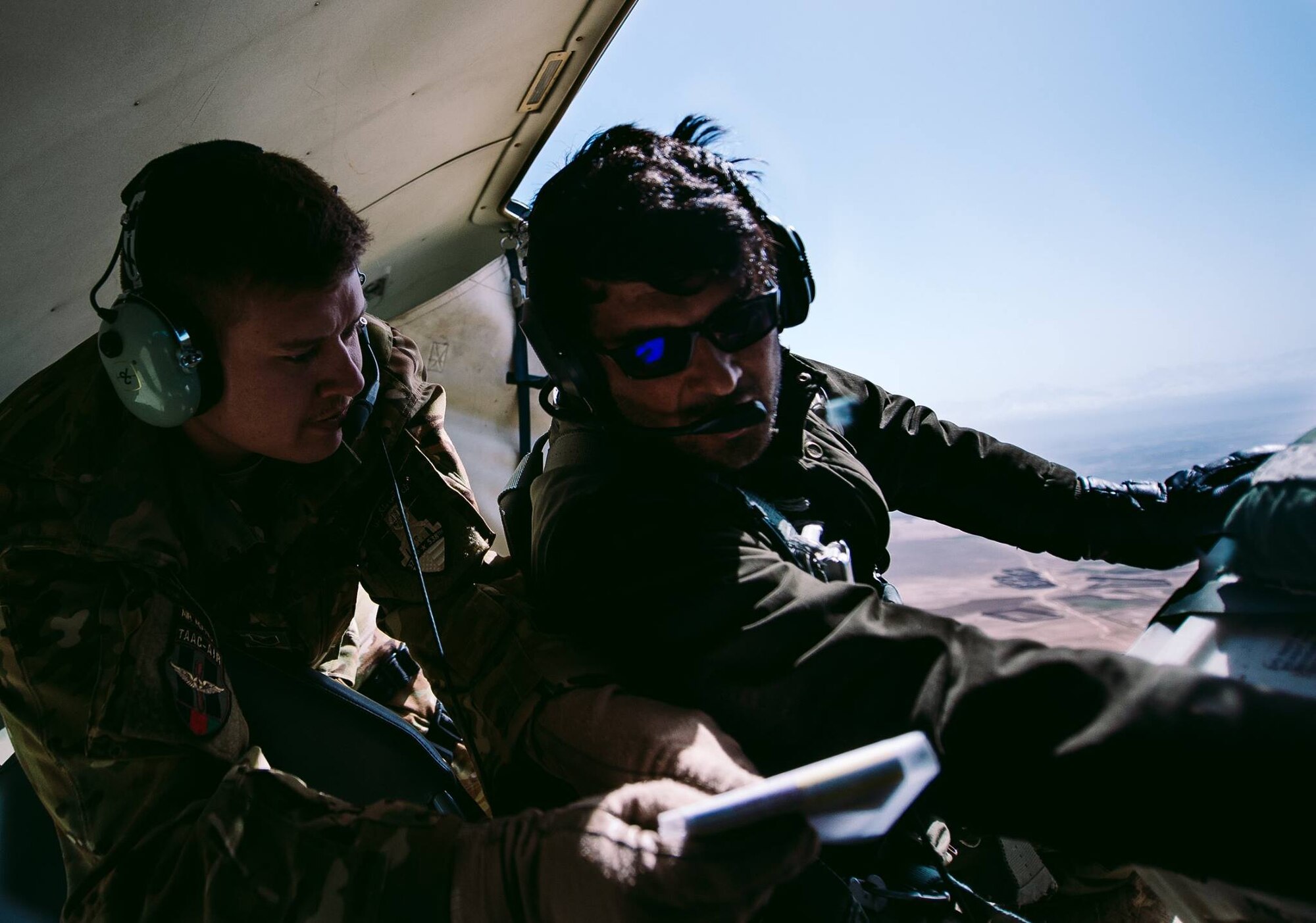U.S. Air Force Tech. Sgt. Brian Wahl with the  Train, Advise, Assist Command-Air, as part of Resolute Support Mission, goes through a pre-drop checklist with an Afghan counterpart to practice air drops near Kabul, Afghanistan, March 19, 2017. The TAAC-Air advisors foster working relationships and fortify confidence in the mission. (U.S. Air Force photo by Senior Airman Jordan Castelan)