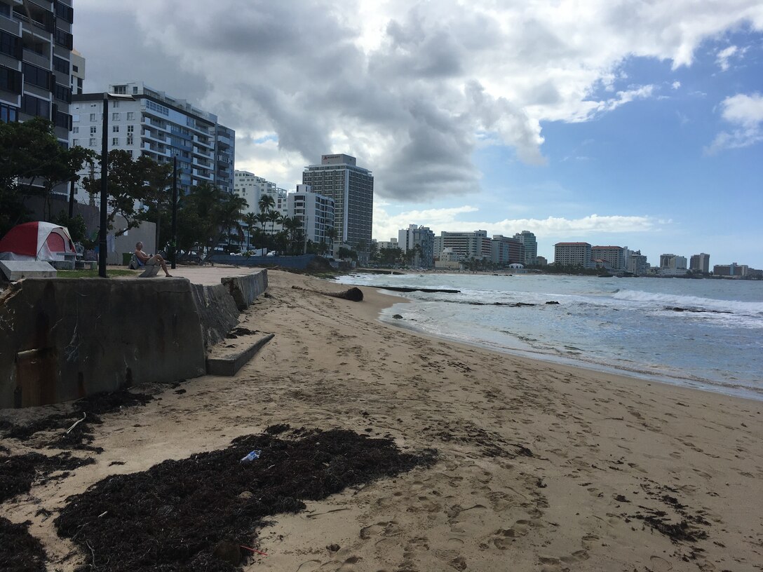 Beach sand with water on the right and buildings on the back in San Juan, Puerto Rico