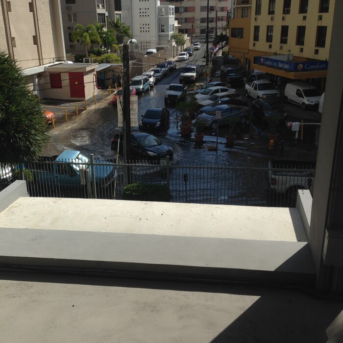several cars in flooded street viewed from a balcony in San Juan, Puerto Rico