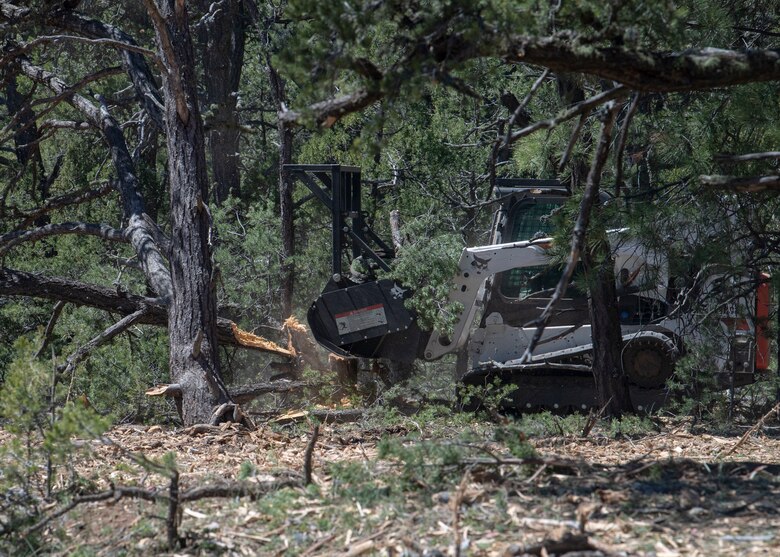 Kevin Pacheco, fire operations technician, uses a bulldozer to masticate overgrowth in the forest area of Kirtland Air Force Base, N.M., April 16, 2019. Kirtland is conducting a multi-step wildfire prevention project spanning across 16,000 acres of its eastern-most remote forest area. (U.S. Air Force photo by Staff Sgt. J.D. Strong II)