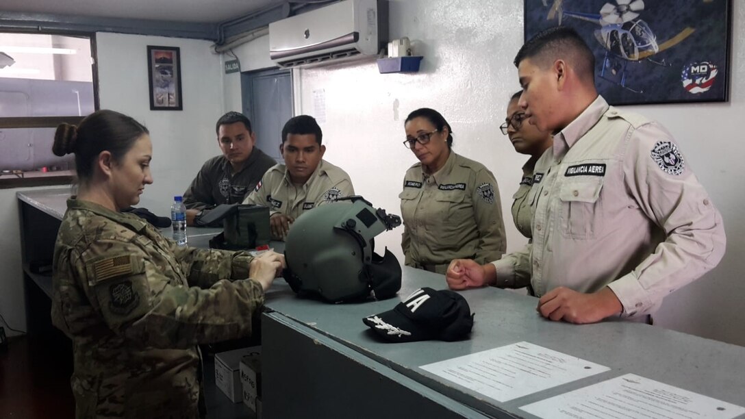 Master Sgt. Natasha Titemore, 571st Mobility Support Advisory Squadron Aircrew Flight Equipment instructor, demonstrates the capabilities of a HGU-56/P helicopter helmet to members of the Costa Rican Air Vigilance Service, March 29, 2019.  The SVA members completed the 2-week course in preparation of their new established AFE work-center in the Base 2 facilities located at the Juan Santamaria International Airport in Costa Rica. (U.S. Air Force photo by Master Sgt. Robert Ramirez)