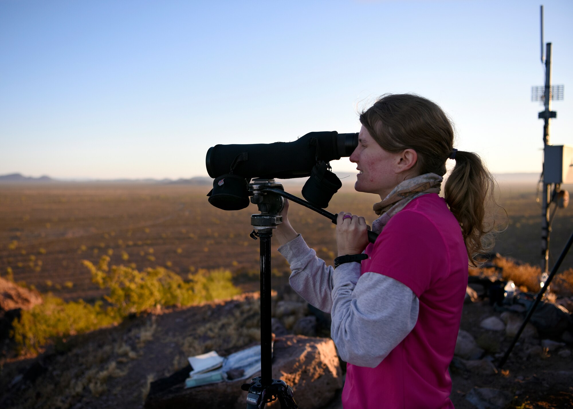 Courtney Kipp, Tunista Services Pronghorn biologist, peers through an observation scope April 17, 2019, at the Barry M. Goldwater Range East in Wellton, Ariz.