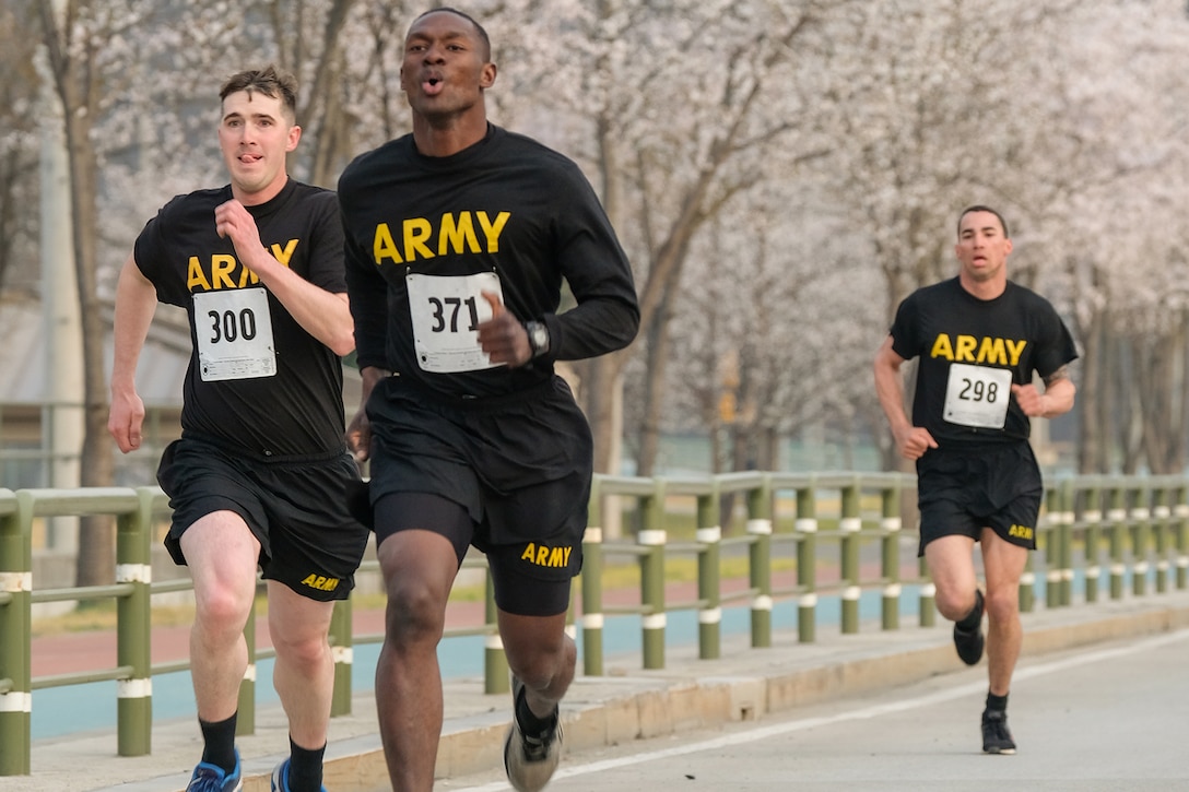 Soldiers sprint to the finish line in a race.