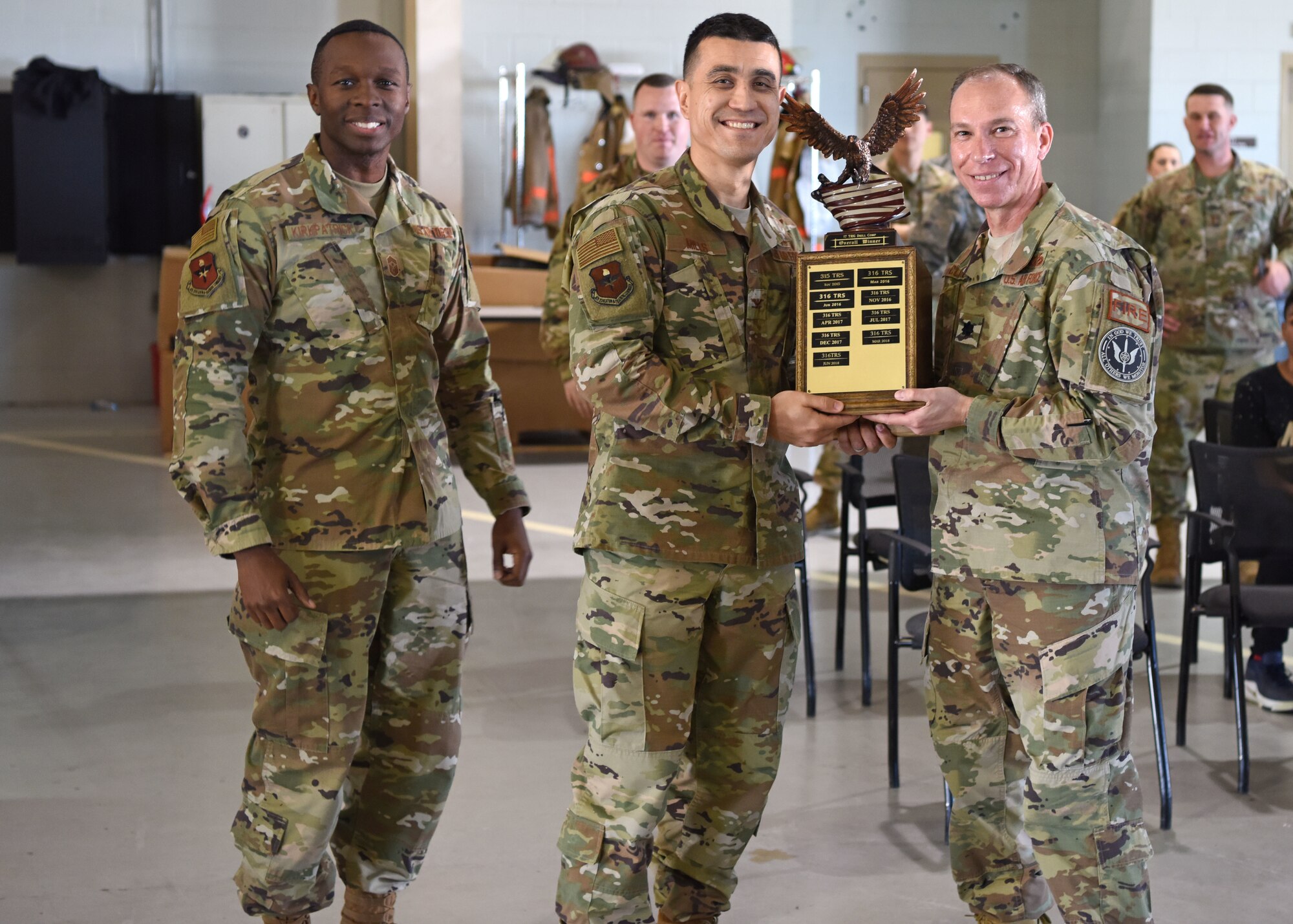 U.S. Air Force Chief Master Sgt. Lavor Kirkpatrick, 17th Training Wing command chief, and Col. Ricky Mills, 17th Training Wing commander present Lt. Col. Scott Cline, 312th Training Squadron commander, the award for the 312th TRS after winning the 17th TRG Drill Competition overall at the Louis F. Garland Department of Defense Fire Academy on Goodfellow Air Force Base, Texas, April 19, 2019. The drill competition is an opportunity for students to show off their marching prowess, discipline and unity. (U.S. Air Force photo by Airman 1st Class Ethan Sherwood/Released)