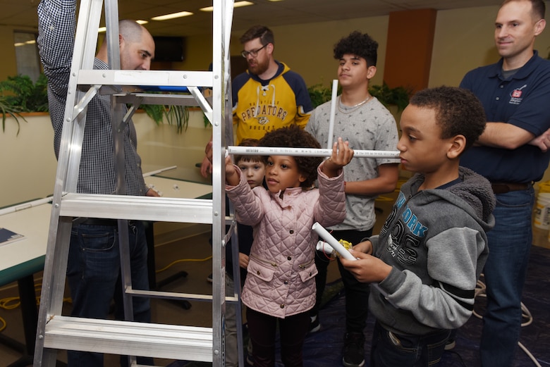 Family members put together a pipe with a water pump that generates electricity, much like a hydropower plant, during the U.S. Army Corps of Engineers Nashville District Bring Your Family to Work Day April 19, 2019 at the Nashville District Headquarters in Nashville, Tenn.  (USACE photo by Lee Roberts)