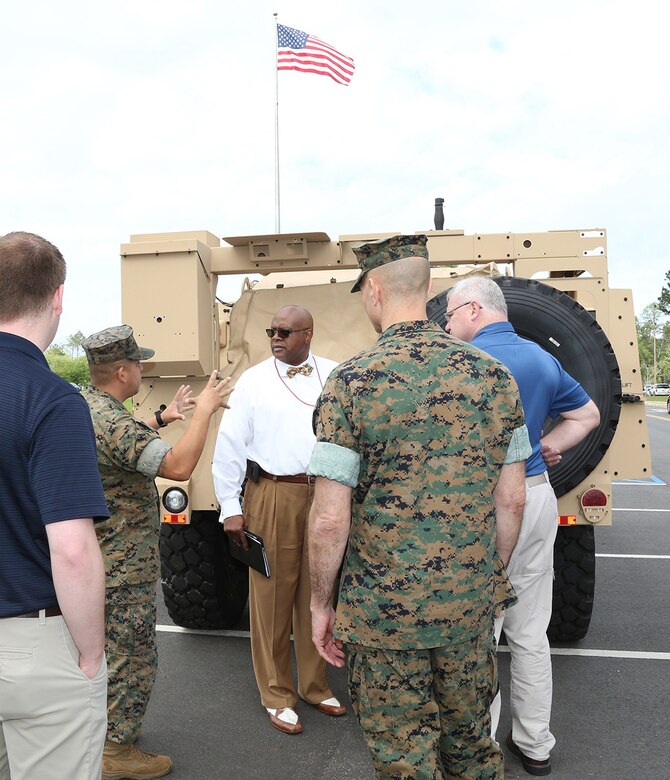 Marines and civilian-Marines discuss the capabilities of the Joint Light Tactical Vehicle, which will take place of the Humvee, during a roadshow in front of MARCORLOGCOM Headquarters, April 9.