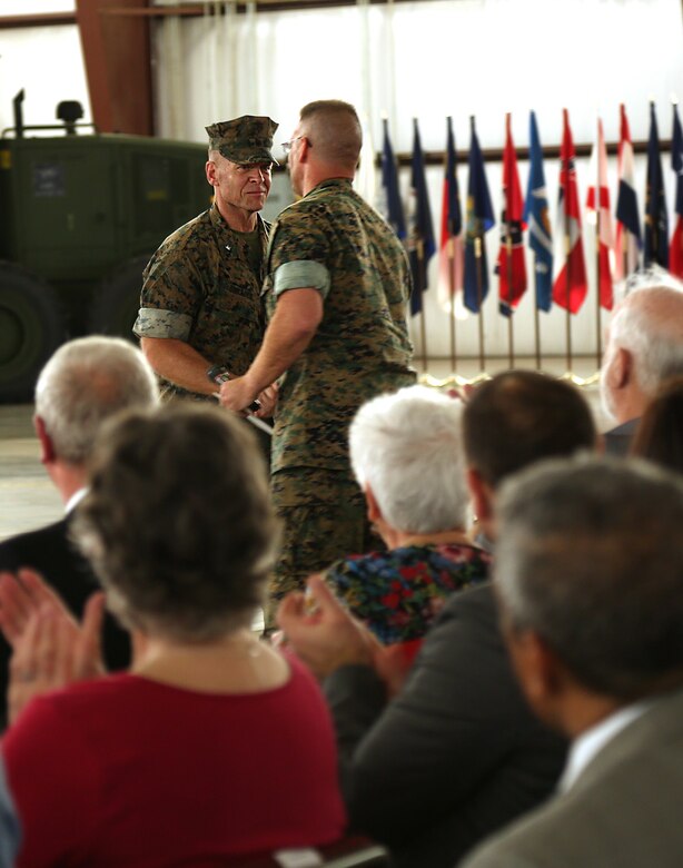 Brig. Gen. Joseph F. Shrader, commanding general, Marine Corps Logistics Command, congratulates Col. Kipp Wahlgren, commanding officer, Marine Force Storage Command, on his new assignment during MFSC’s activation ceremony held aboard Marine Corps Logistics Base Albany, Ga., April 11.