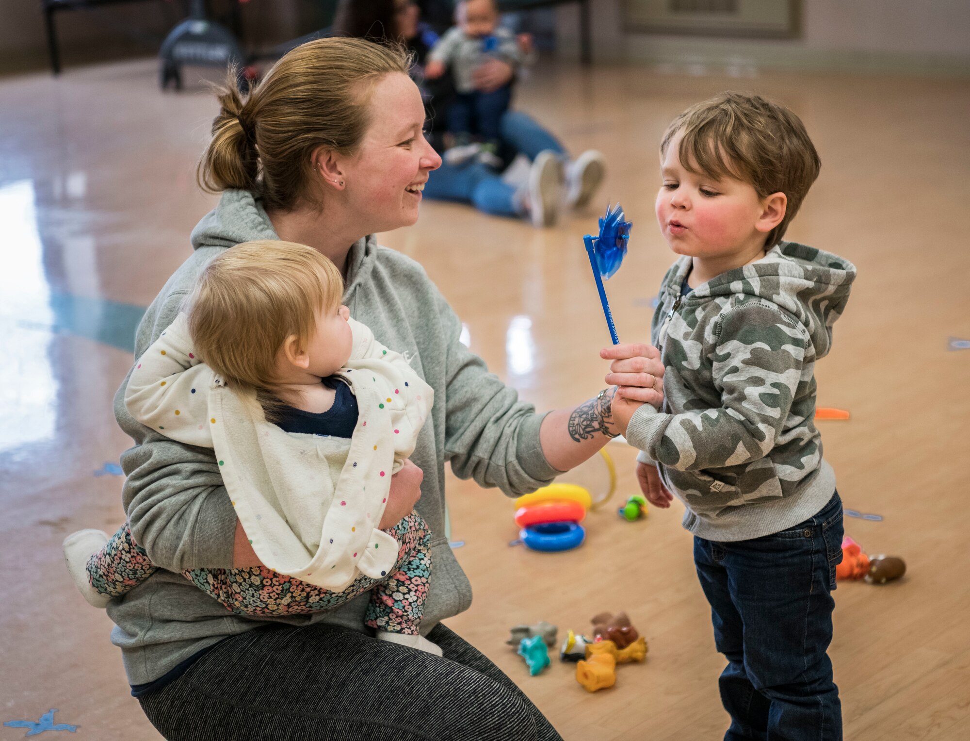 Ashley Richard and her children, Andi and Lee Richard, inspect a pinwheel during the Family Advocacy Program’s Play Group Easter Egg Hunt held in recognition of National Child Abuse Prevention Month, on April 17, 2019, at Dover Air Force Base, Del. During the event, Family Advocacy Program educators handed out blue pinwheels to all attendants. In 2008, the pinwheel became the national symbol for child abuse prevention. (U.S. Air Force photo by Senior Airman Christopher Quail)