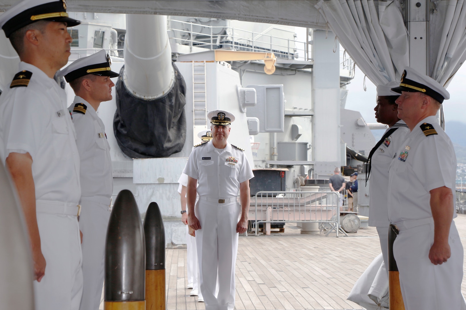 An Indian Navy sailor adjusts his colleague's uniform prior to the