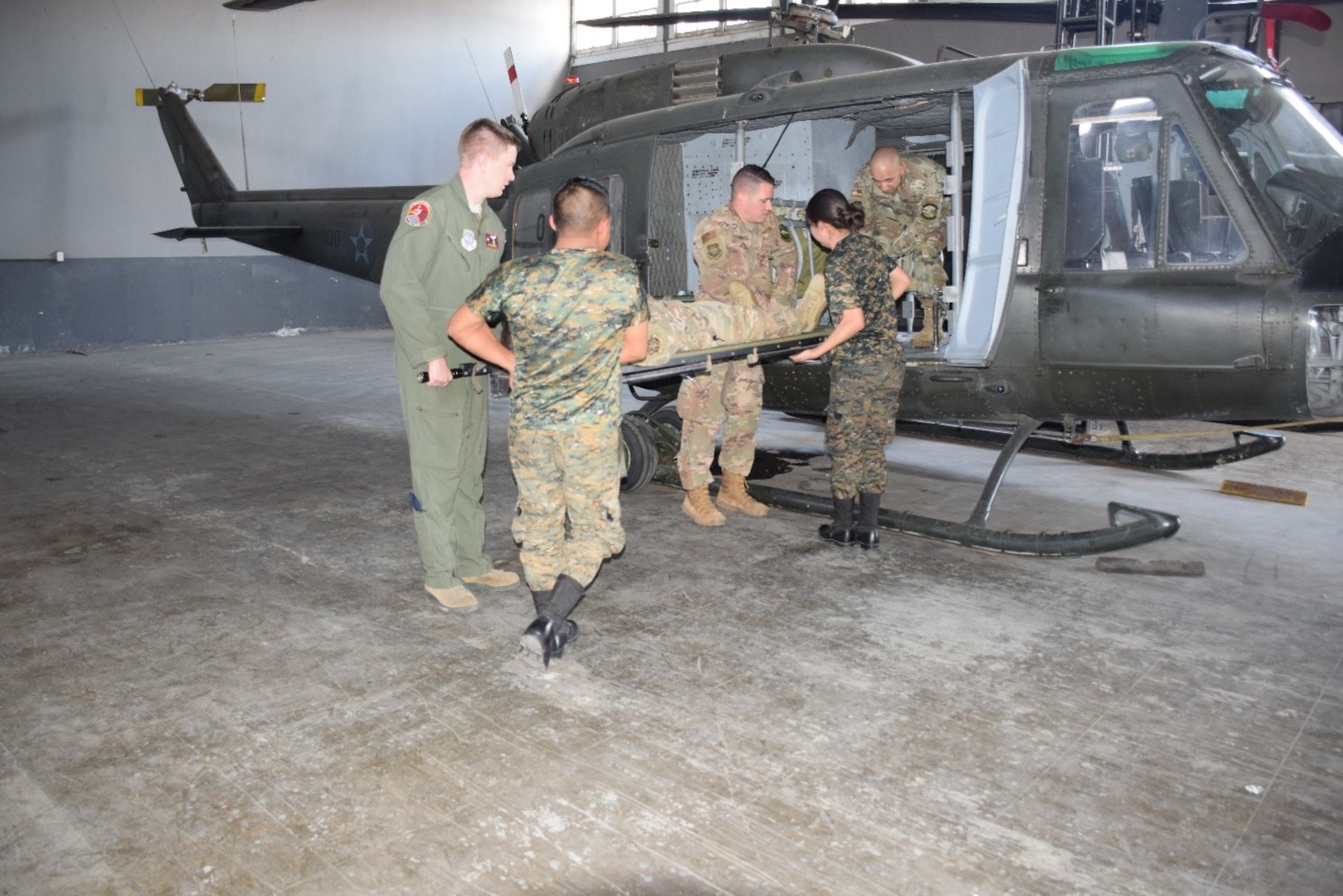 Air advisors from the 571 Mobility Support Advisory Squadron, and Guatemalan air force students practice loading a litter patient into the partner nation’s UH-1 aircraft during a mobile training mission at Aurora Air Base in Guatemala. The students are part of the first aeromedical evacuation unit in the Guatemalan air force. (Courtesy Photo)