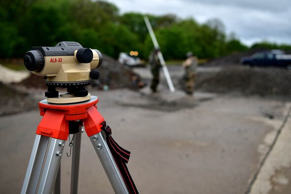 A piece of equipment that is red, gray and tan is in the foreground.