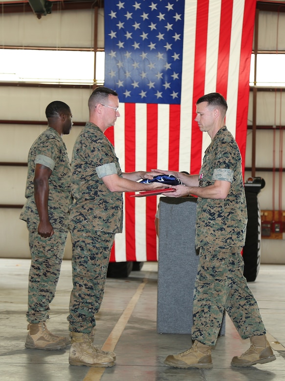 Maj. Jason J. Gates, right, operations officer, Marine Force Storage Command,  receives an American flag from Lt. Col. Timothy B. Egan, director, Fleet Storage Division-Albany, MFSC, during a ceremony held at the Building 1430 aboard Marine Corps Logistics Base Albany, Ga., April 19. Gates retired after 22 years of honorable service in the Marine Corps.