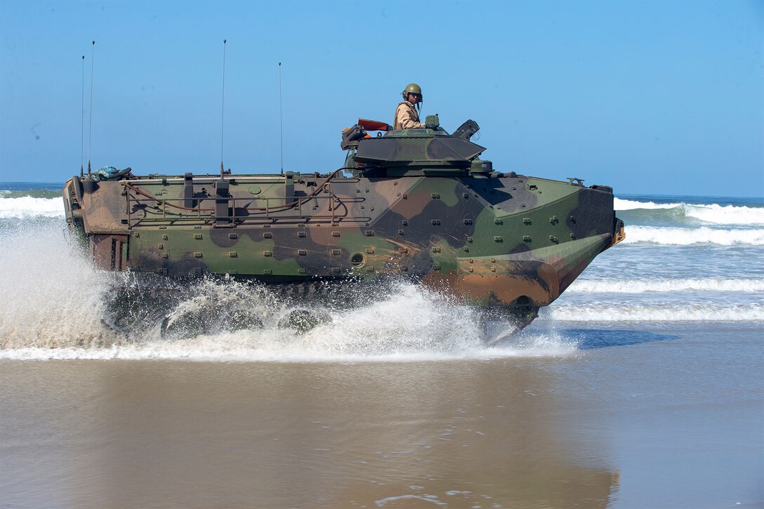 A Marine guides the driver of a vehicle.