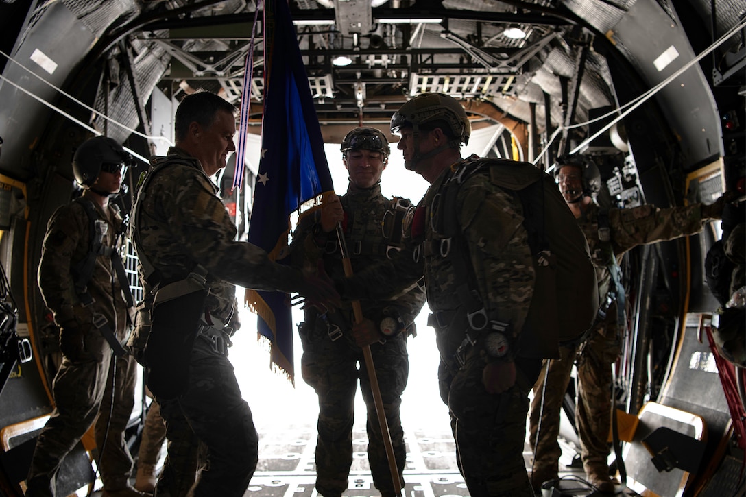 A member of the Air Force relinquishes command of an operations wing in a ceremony on an aircraft.