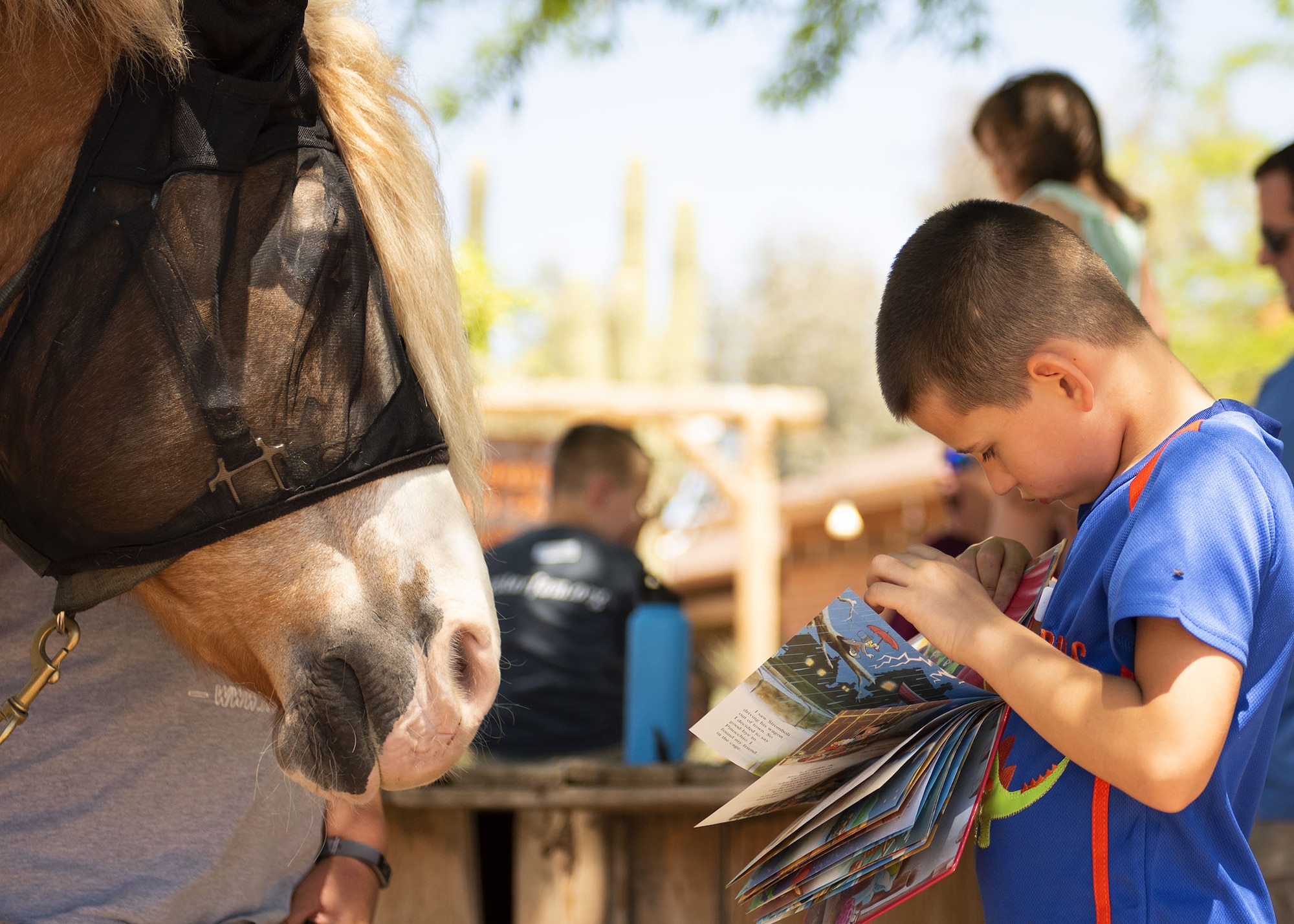 A child reads to a horse at Horses Help, April 20, 2019, in Phoenix, Ariz.