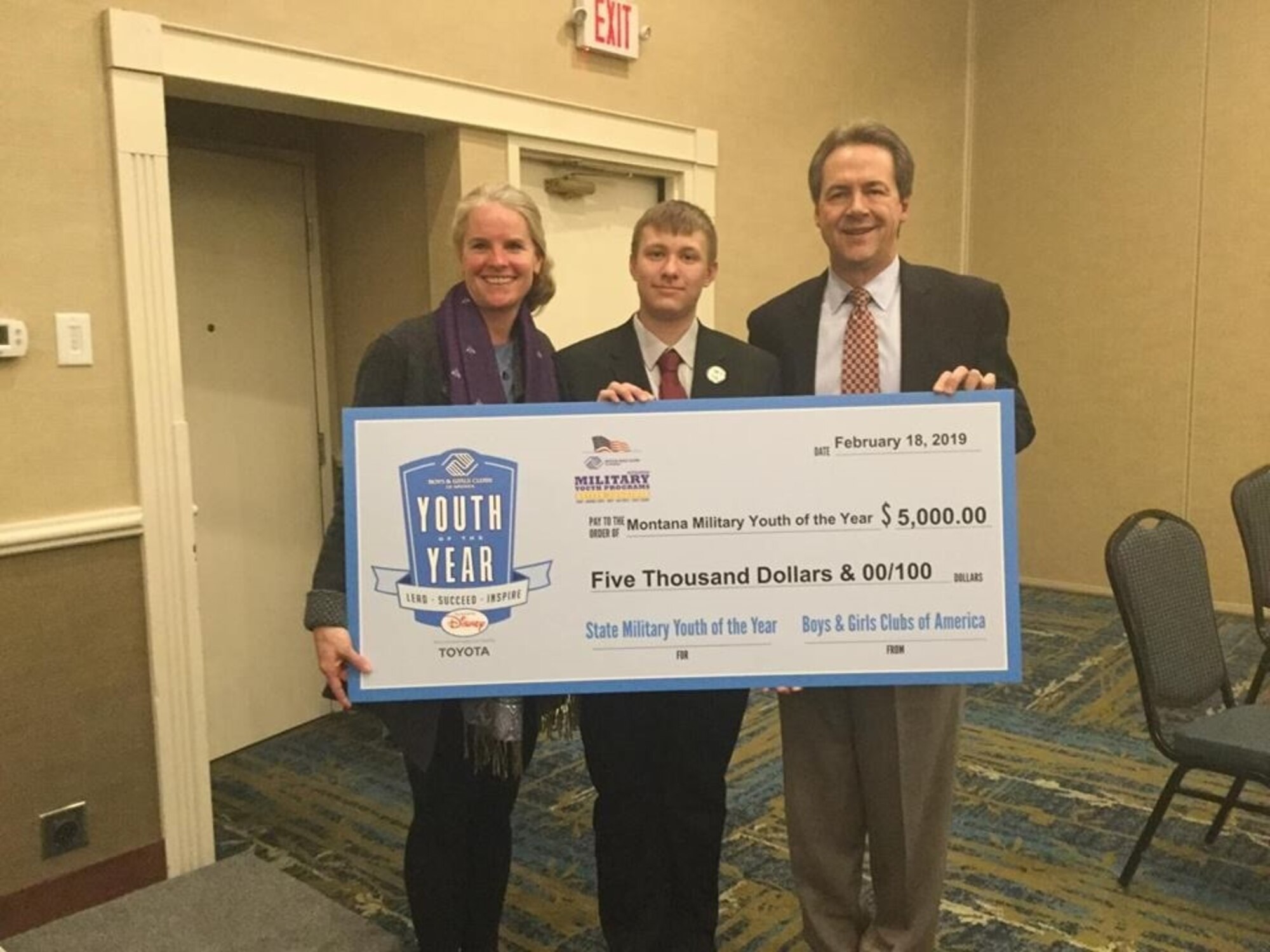Anthony Harris, 2019 Montana State Military Youth of the Year, receives a college scholarship check from Mont. Gov. and Mrs. Steve Bullock.