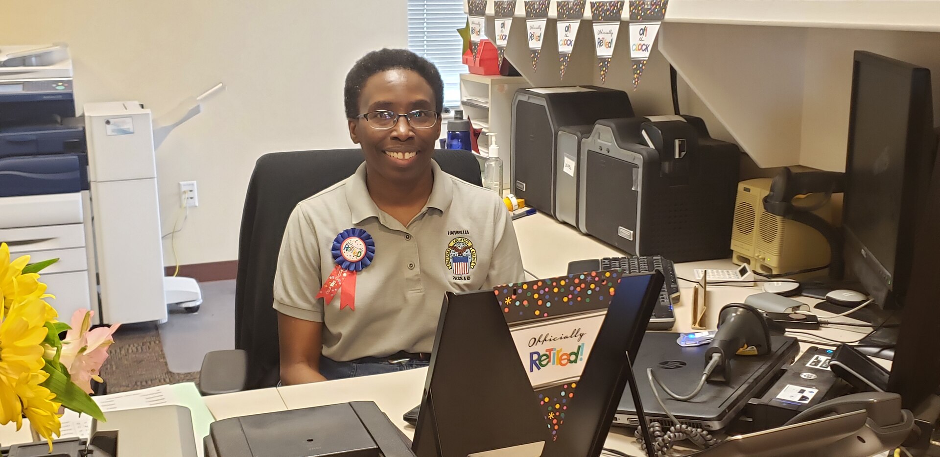 Female associate sits behind desk decorated for retirement flags