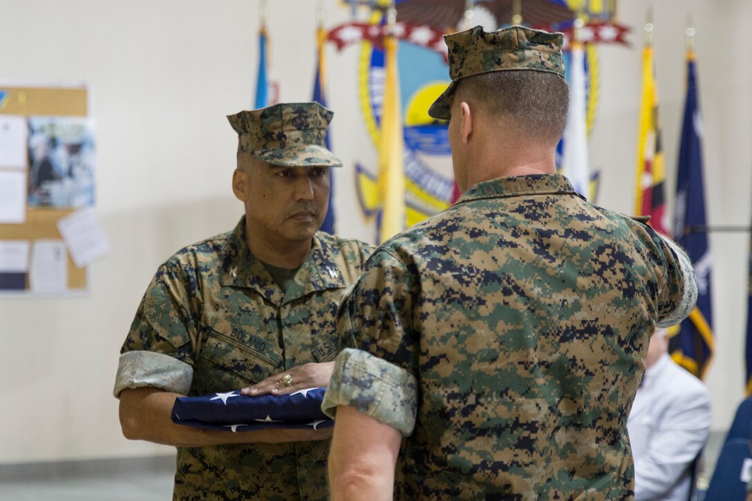 Col. Augustin Bolanio receives his retirement flag during his retirement ceremony at U.S. Marine Corps Reserve Training Center, April 13, 2019.