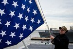 Woman raises a flag on a ship