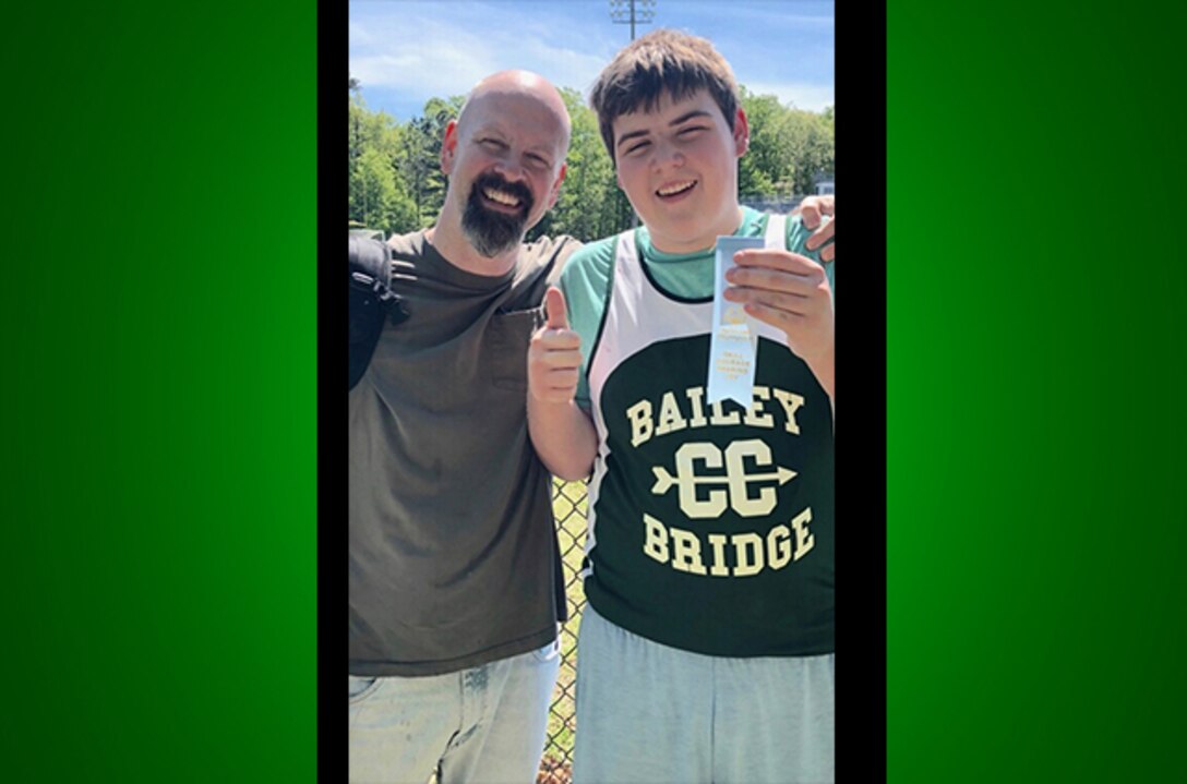 Christian poses with ribbon and dad