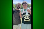 Christian poses with ribbon and dad