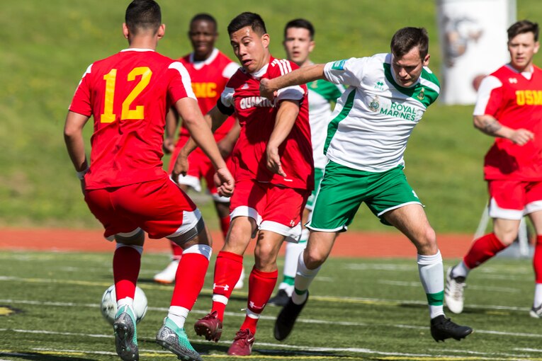 U.S. and British Marines play soccer on a field.