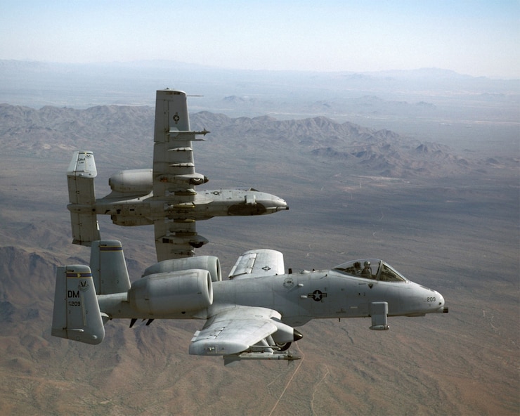 A photo of two A-10 Thunderbolt IIs flying over mountains