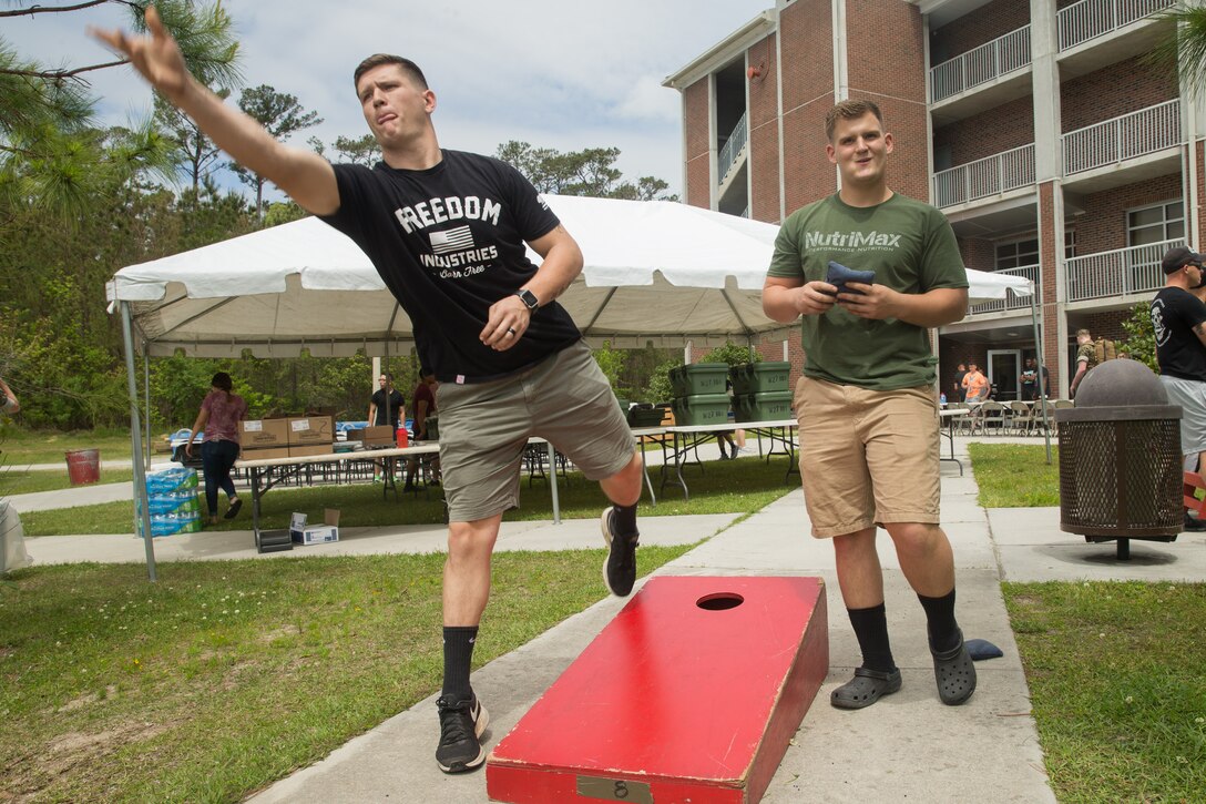 U.S. Marine Corps Lance Cpl. Andrew Nevius, right, and Cpl. Banner Napier, right, play cornhole during a barracks bash hosted by Combat Logistics Regiment 27 on Camp Lejeune, North Carolina, April 18, 2019.  The purpose of the barracks bash was to celebrate completed barracks renovations, strengthen cohesion, foster a positive atmosphere and enhance the quality of life for Marines and Sailors. (U.S. Marine Corps photo by Cpl. Damion Hatch Jr)