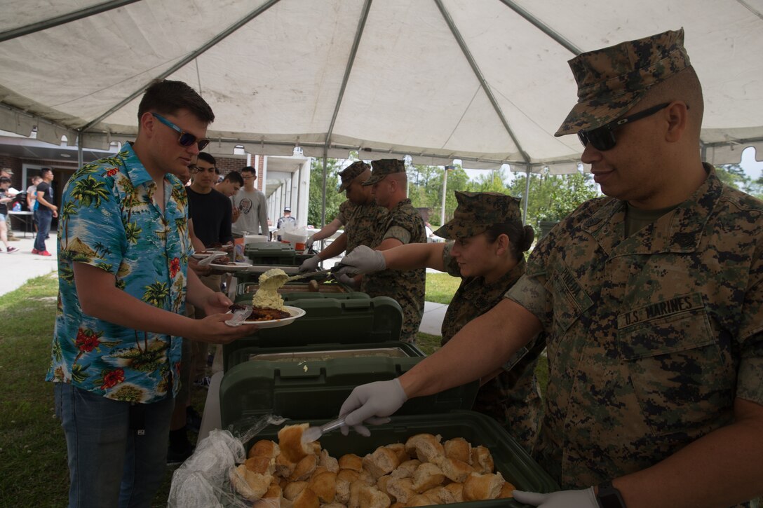 U.S. Marines with Combat Logistics Regiment 27, 2nd Marine Logistics Group, serve food during a barracks bash on Camp Lejeune, North Carolina, April 18, 2019.  The purpose of the barracks bash was to celebrate completed barracks renovations, strengthen cohesion, foster a positive atmosphere and enhance the quality of life for Marines and Sailors. (U.S. Marine Corps photo by Cpl. Damion Hatch Jr)