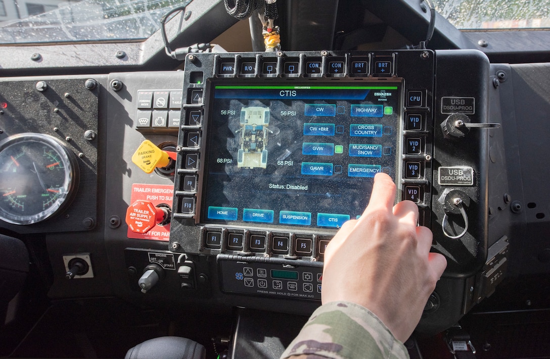 A soldier uses a touchscreen computer inside a joint light tactical vehicle.