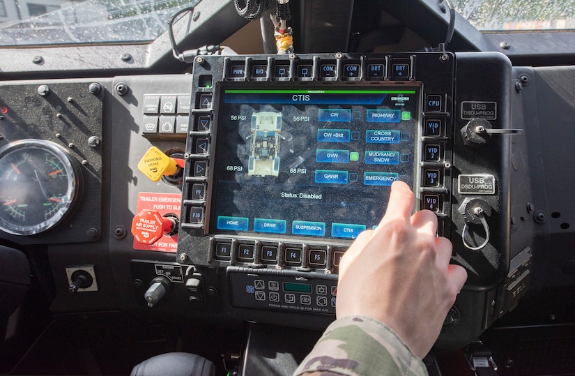 A soldier uses a touchscreen computer inside a joint light tactical vehicle.