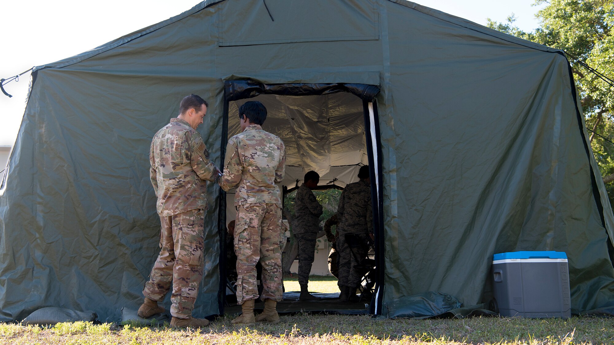 Airmen participating in the Operation Open Horizon training exercise at MacDill Air Force Base, Fla, converse outside of a tent April 16, 2019. The 6th Contracting Squadron partnered with the 6th Comptroller Squadron in a simulated deployment to a forward operating base being stood up to deter a fictional aggressor.