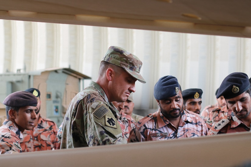 U.S. Army Sgt. 1st Class Chad Collins and Royal Army of Oman Soldiers inspect a tire after removing rim cover during the Heavy Equipment Transporter System Subject Matter Exchange II held at Sultan bin Safy Camp Shafa Oman, April 6-11, 2019.