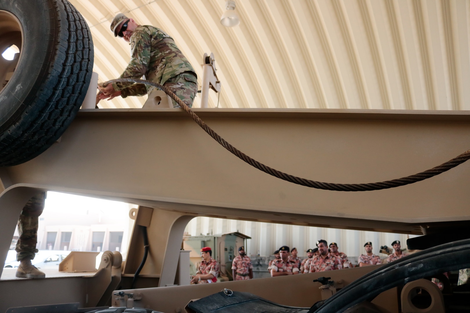 U.S. Army Staff Sgt. Andrew Jones feeds a winch cable while demonstrating to Royal Army of Oman Soldiers how to correct a malfunction during the Heavy Equipment Transporter System Subject Matter Exchange II held at Sultan bin Safy Camp Shafa Oman, April 6-11, 2019.