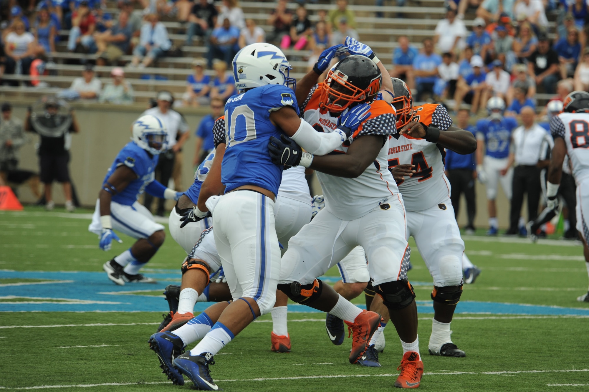 Air Force Academy defensive end Ryan Watson, left, pushes the left tackle back while trying to read the quarterback’s play, during the Academy’s 2015 win over Morgan State University. Watson played three seasons at defensive end and one at outside linebacker at the Air Force Academy, and registered eight sacks during his senior year. Now a program manager with AFLCMC, Watson has been invited to showcase his defensive skills at the Detroit Lions rookie minicamp, May 10-13. (U.S. Air Force photo/John Van Winkle).