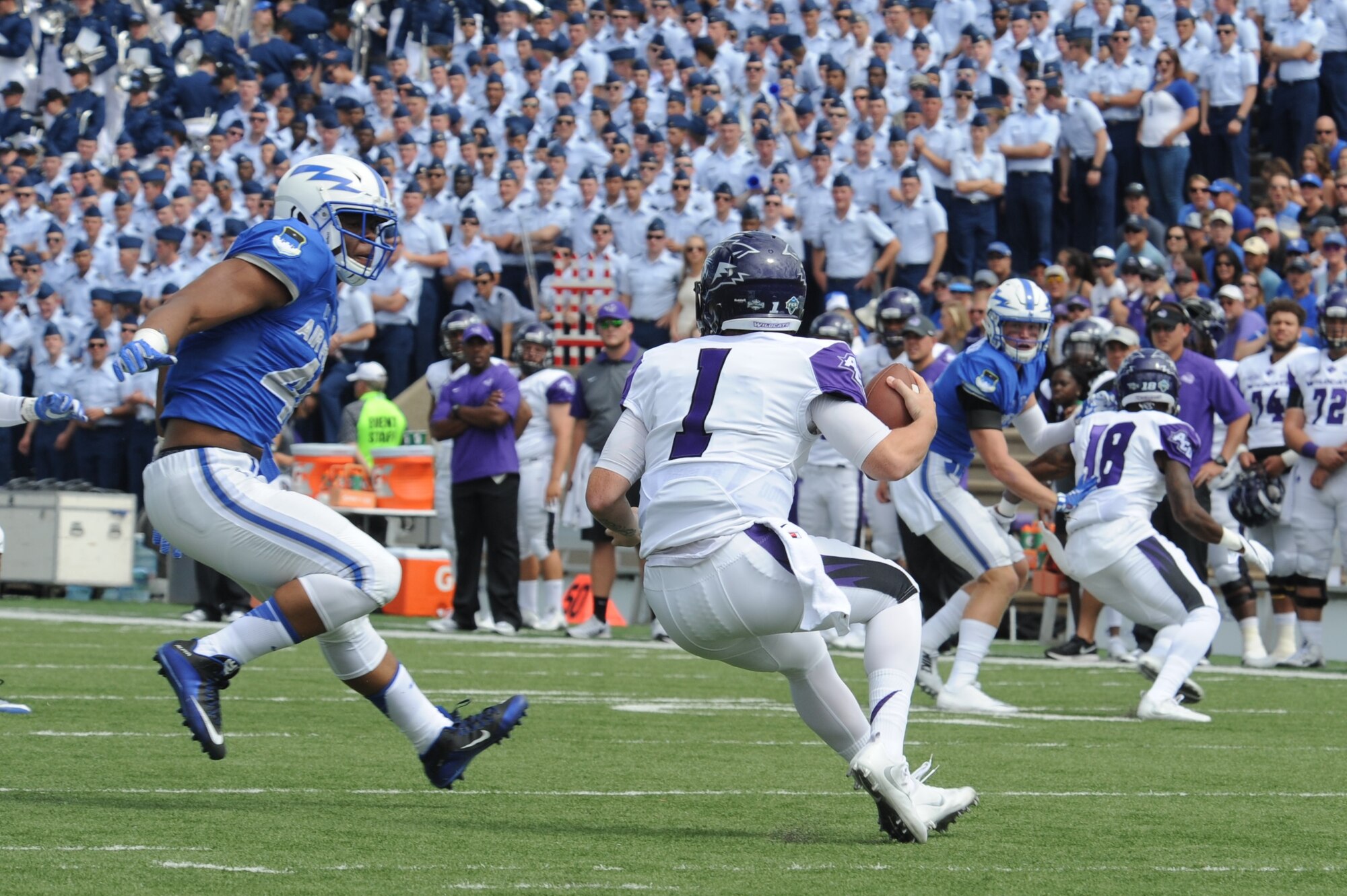 Air Force Academy defensive end Ryan Watson, left, disrupts a play and prepares to abruptly introduce himself to a quarterback, during the Academy’s 2016 win over Abilene Christian University. Watson played three seasons at defensive end and one at outside linebacker at the Air Force Academy.  Now a program manager with AFLCMC, Watson has been invited to the Detroit Lions rookie minicamp, May 10-13. (U.S. Air Force photo/John Van Winkle)