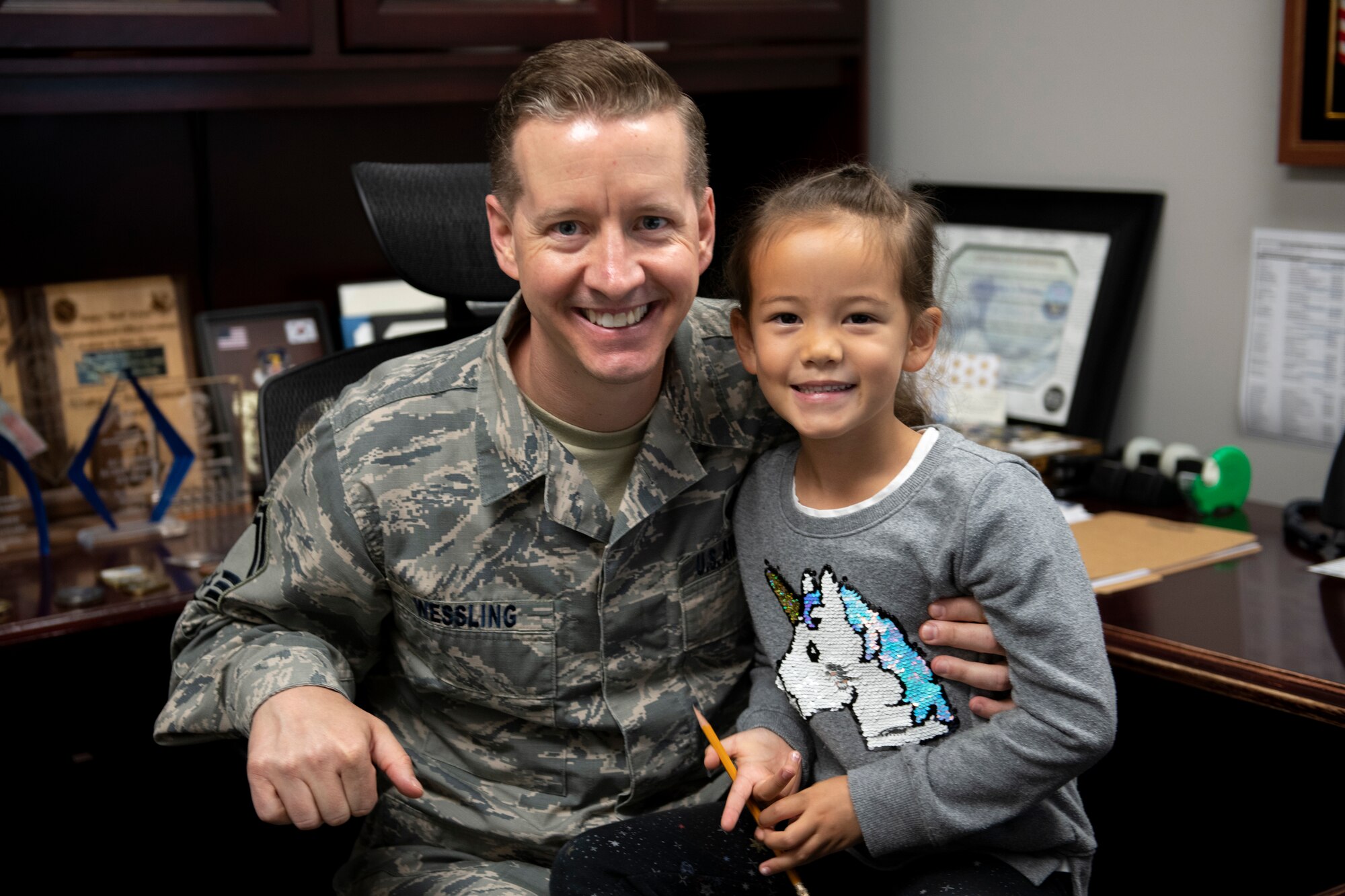 U.S. Air Force Senior Master Sgt. Joshua Wessling, 33rd Fighter Wing wing staff superintendent, and his daughter pose for a photo in his office Apr. 25, 2019, at Eglin Air Force Base, Florida. April is "Month of the Military Child" across the Department of Defense and Wessling takes every opportunity to spend time with his children who join him on his military journey. (U.S. Air Force Photo by Senior Airman Cassidy Woody)