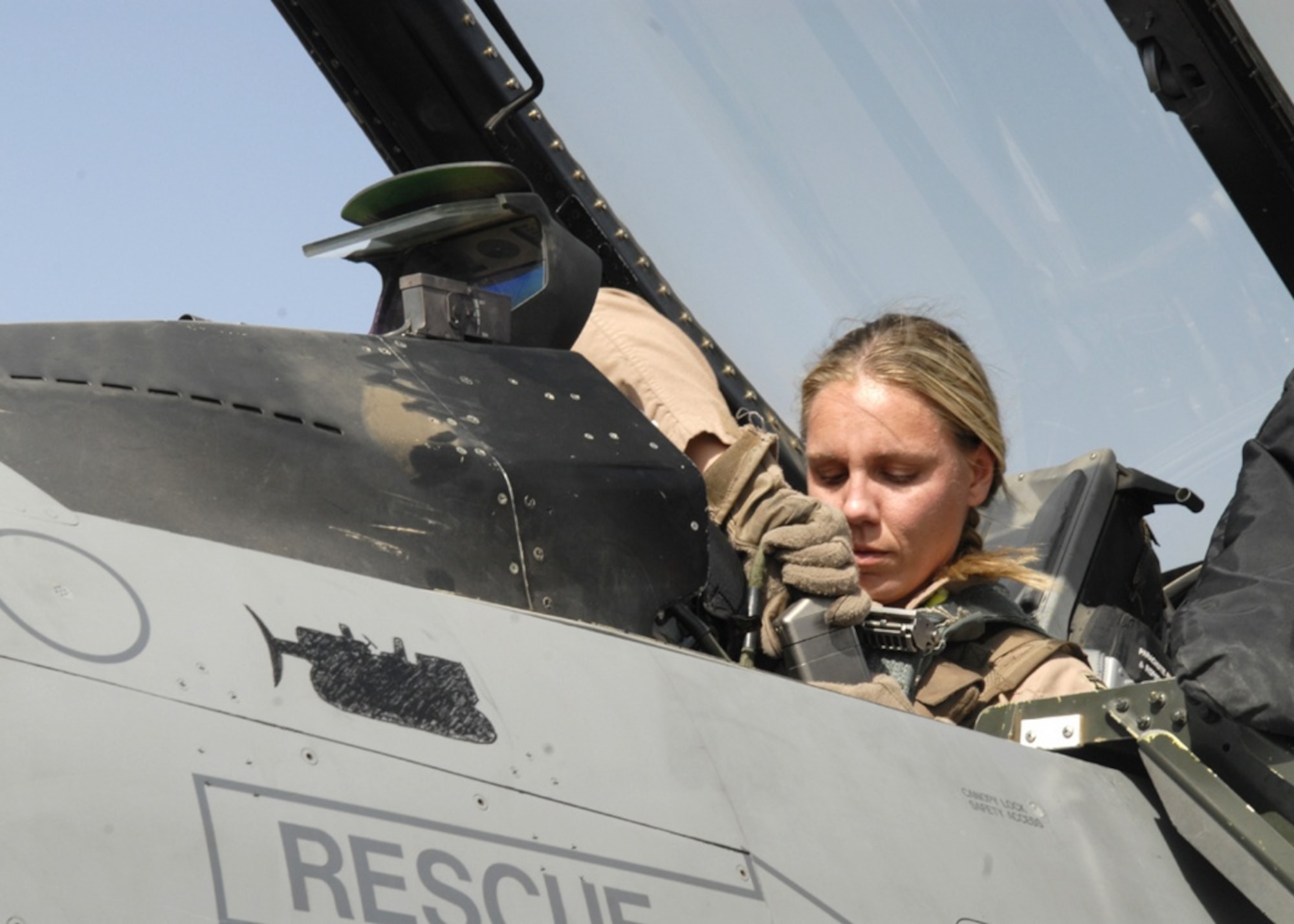 U.S. Air Force pilot Capt. Caroline Jensen, from the 4th Expeditionary Fighter Squadron, connects the communications receiver to her helmet ensuring she is in contact with personnel on the ground prior to taking off in an F-16 Fighting Falcon from Balad Air Base. Jensen is deployed from Hill Air Force Base, Utah. (U.S. Air Force Photo/Staff Sgt. Joshua Garcia, Released)