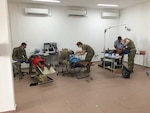 U.S. Army dentists Lt. Col. Eric Unkenholz, Col. Murray Thompson, and Maj. Kevin Donlin and Staff Sgt. Samantha Wempe, dental technician, all with the South Dakota National Guard, perform dental work and tooth extractions on adults and children in Albina, Suriname, April 10, 2019. A SDARNG medical/dental team partnered with Suriname military and civilian medical personnel to assist with ongoing efforts of improving systemic and oral health in the region.